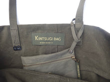 Load image into Gallery viewer, inside a green bag with label kintsugi bag little green pouch fixed with button to the shopper
