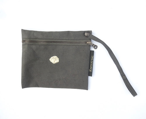 little pouch made of green canvas repaired with japanes kintsugi. The pouch has a copper zip and a string with button to fix on any bag with handles